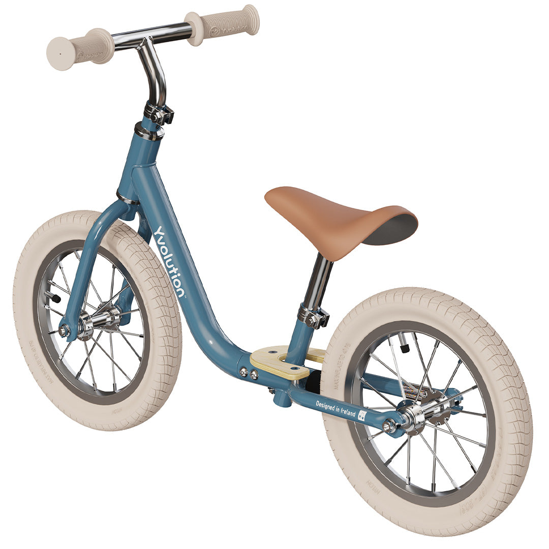 Yvolution blauwe loopfiets met lichtbruin zadel en off-white banden, schuin van achteren gezien.