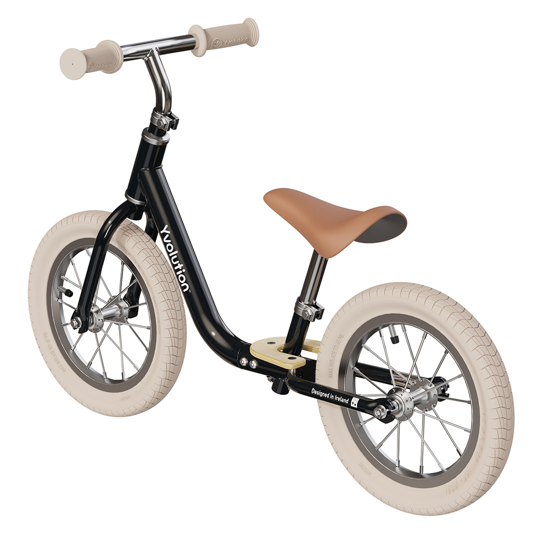Yvolution loopfiets voor peuters, zwart met bruin zadel en crèmekleurige banden, schuin van voren.