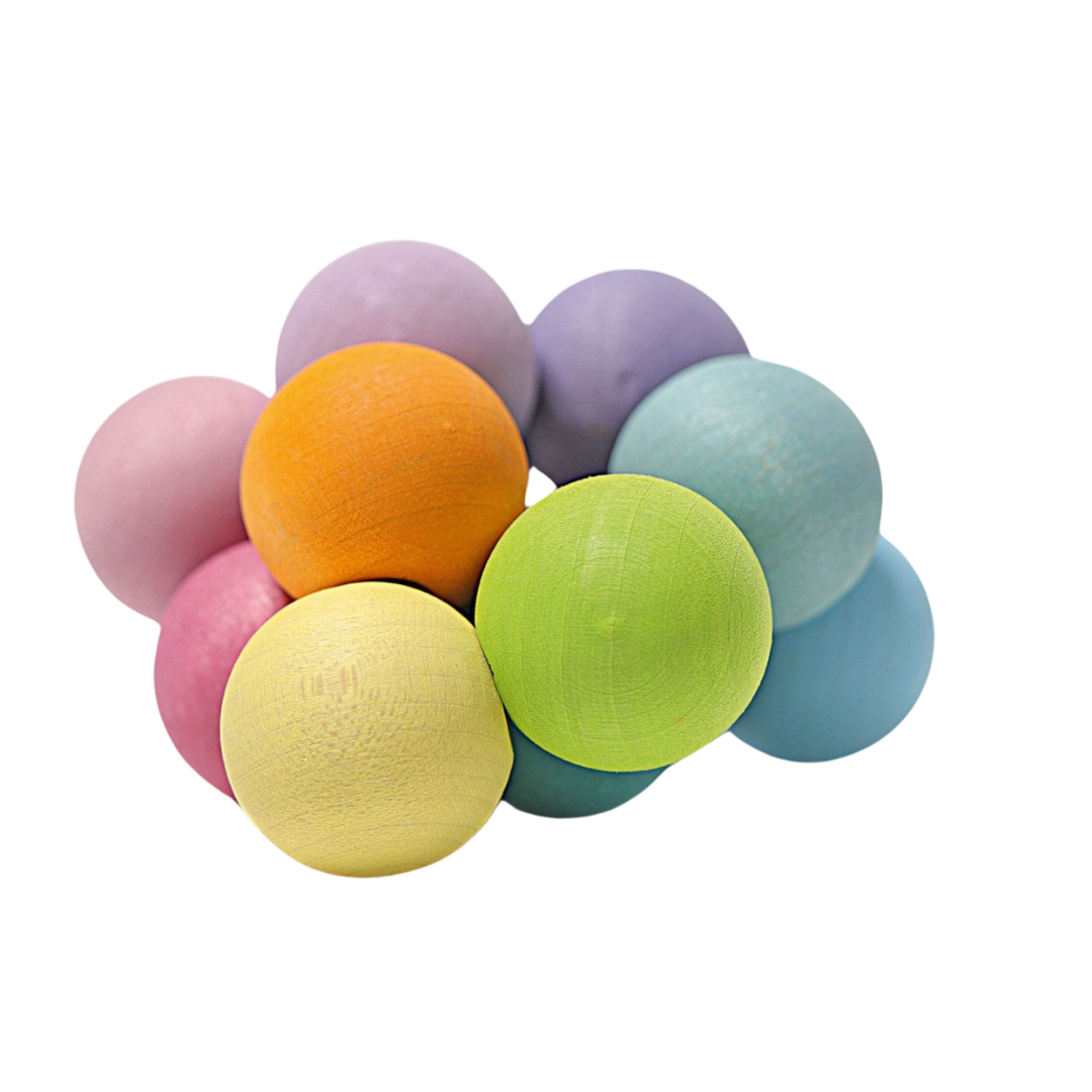Grimm's babyspeelgoed met een hoopje pastelkleurige houten kralen.