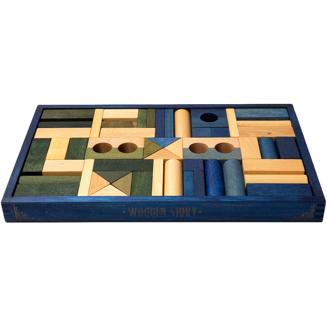 Schuine weergave van de Wooden Story houten bouwblokken set in een blauwe kist, met de merknaam op de zijkant.