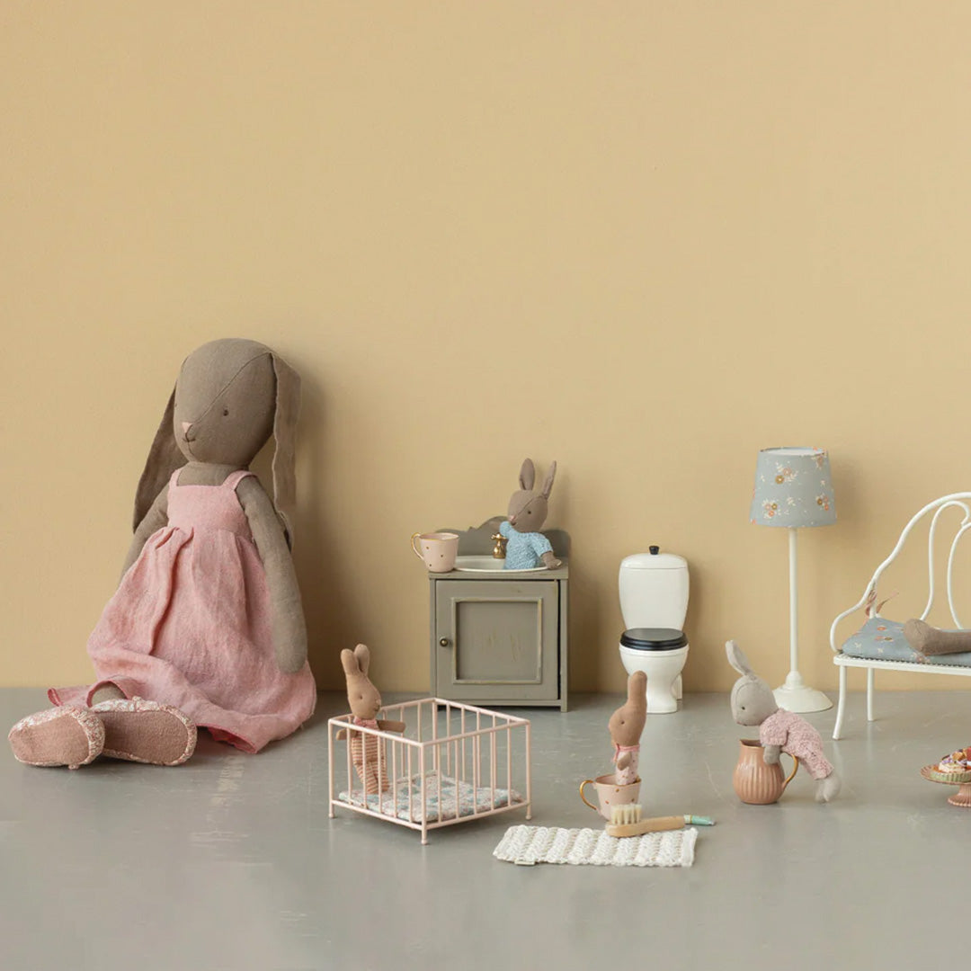 Maileg poppenhuis interieur met diverse meubels en konijnenpoppen, inclusief de roze speelbox.