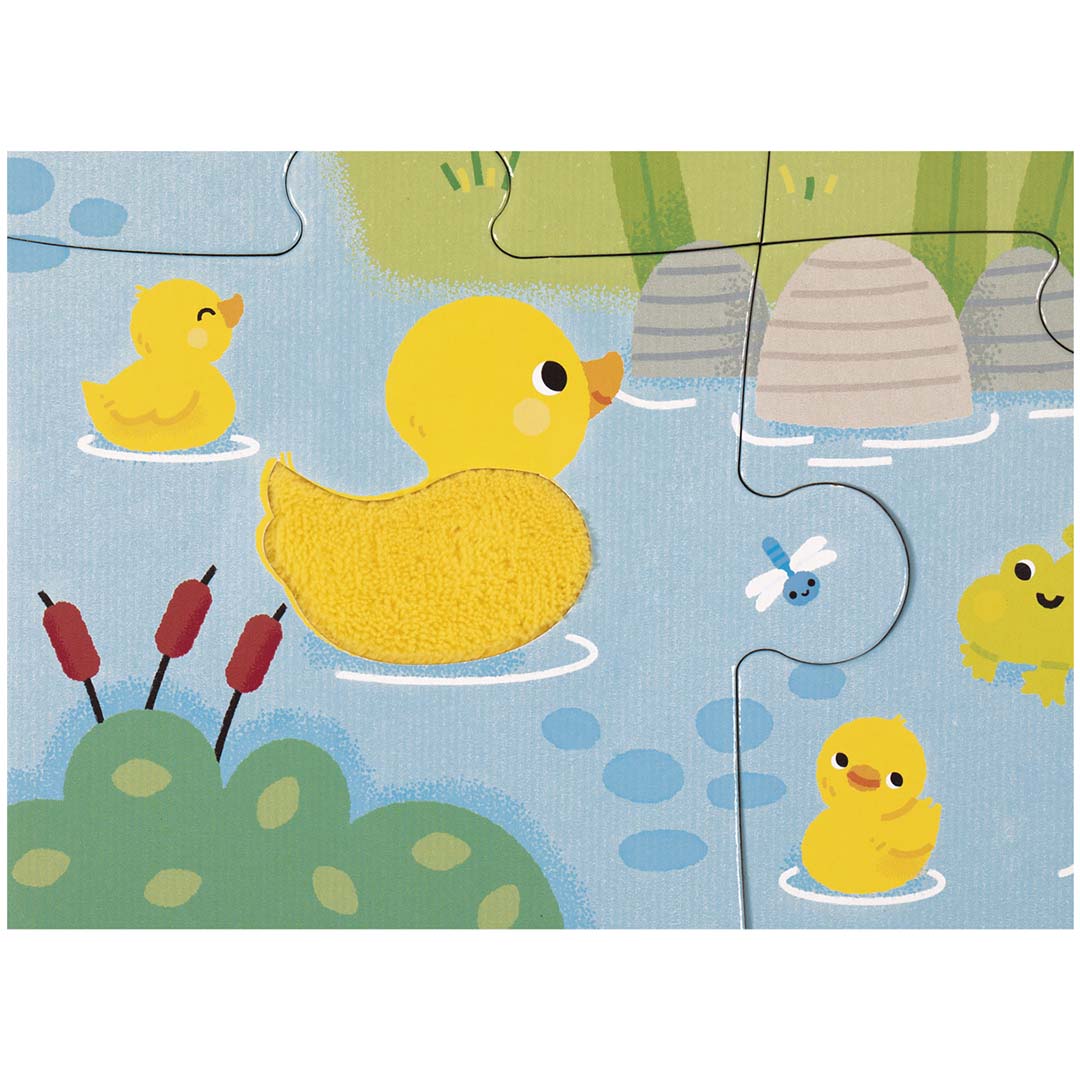 Detail van de Janod voelpuzzel met een gele eend met textuur in het water.