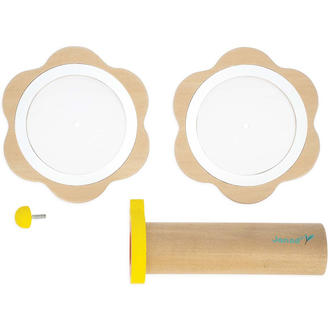 De Janod houten bloemenkaleidoscoop ligt gedemonteerd op een witte ondergrond.