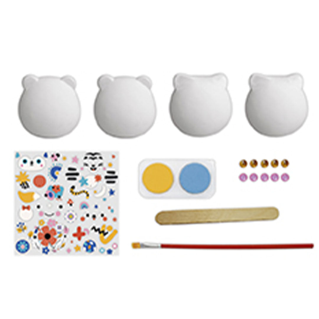 De inhoud van de hobbyset met vier witte gipsdieren, verf, stickers en een kwast.