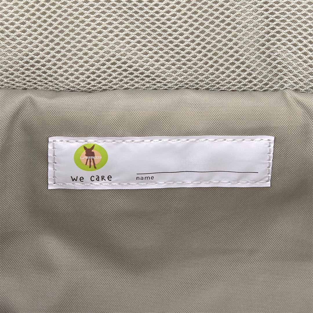Close-up van het "we care" naamlabel in de Lässig toilettas.