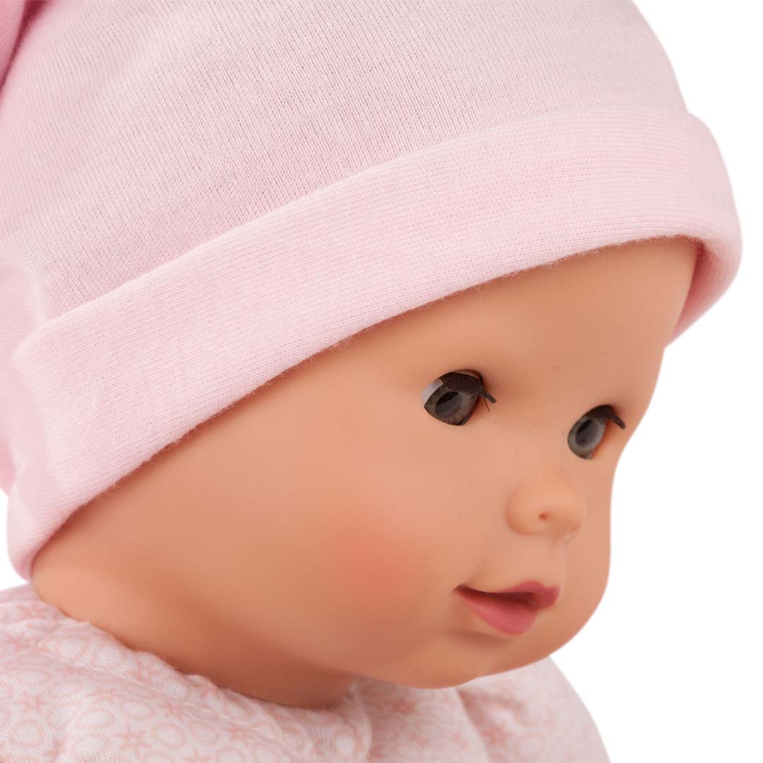 Detailopname van het gezicht van de babypop Maxy Muffin die opzij kijkt.