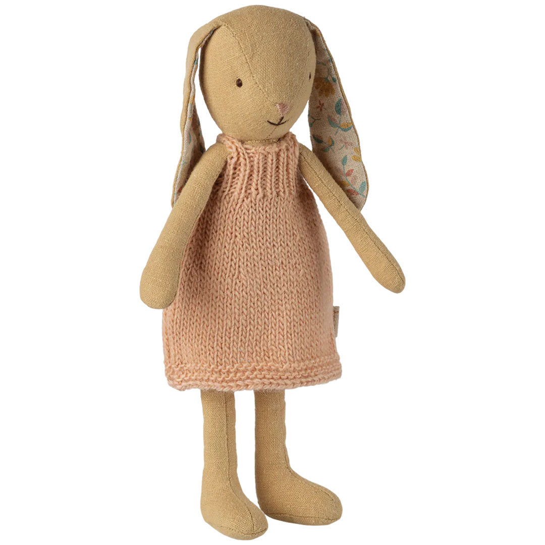 Maileg pluchen knuffelkonijn met een gebreid roze jurkje, staand tegen een witte achtergrond.