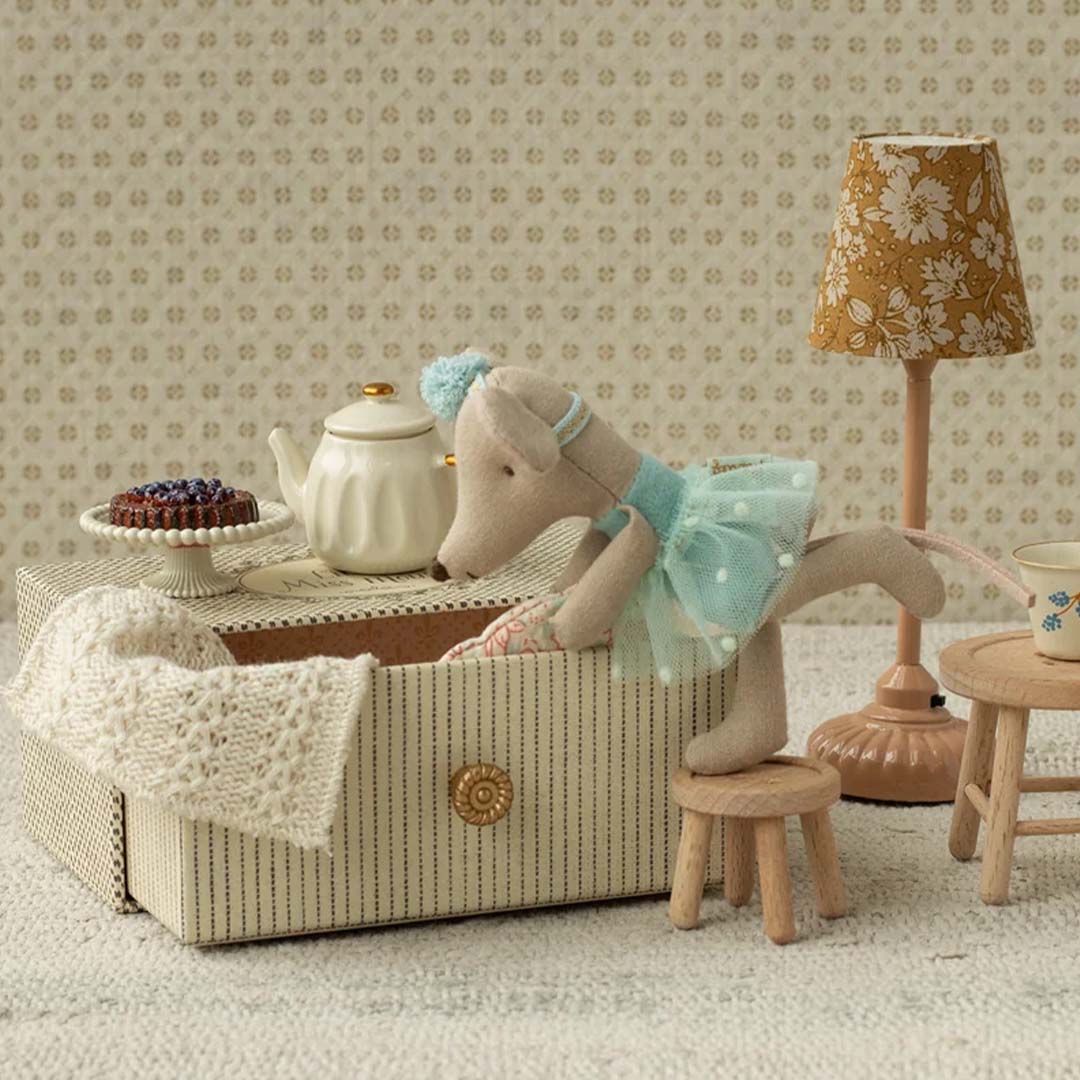 Maileg knuffelmuis in blauwe dansoutfit die uit een gestreepte doos klimt in een miniatuurkamer.