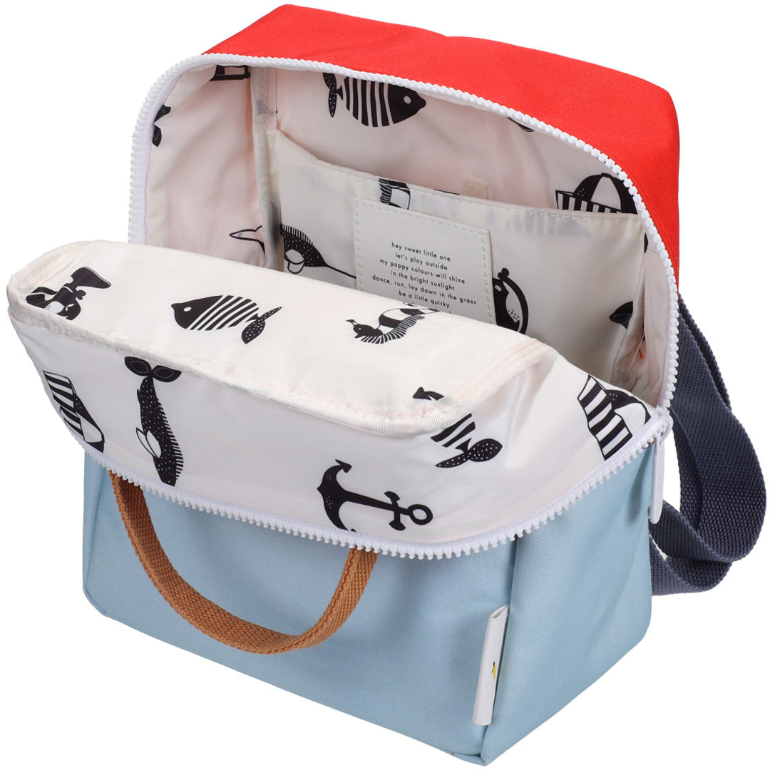 De open colourblocking peuterrugzak toont de binnenvoering met vis- en ankerpatronen.