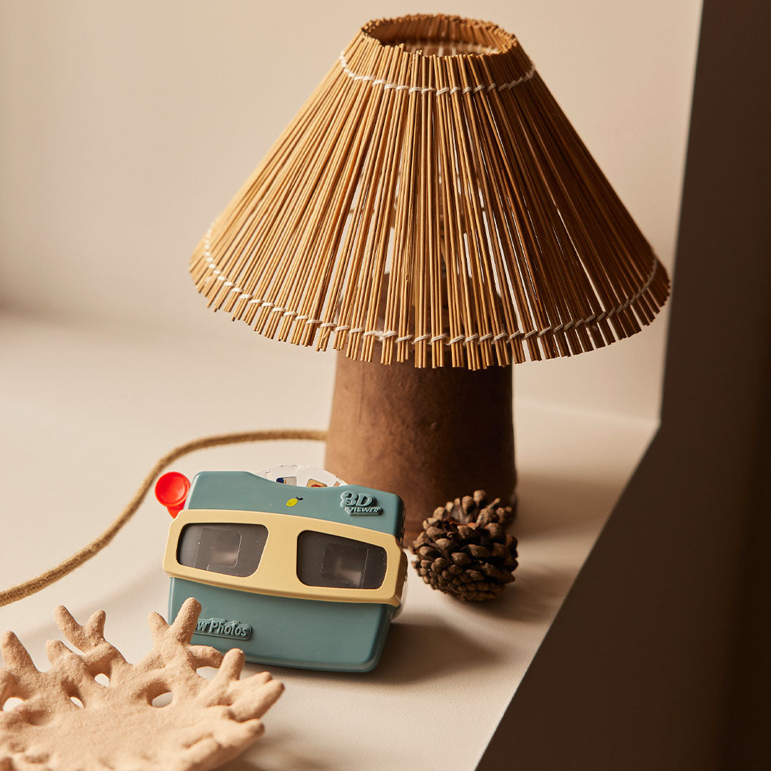 Sticky Lemon viewmaster op een vensterbank naast een rieten lamp en decoratie.