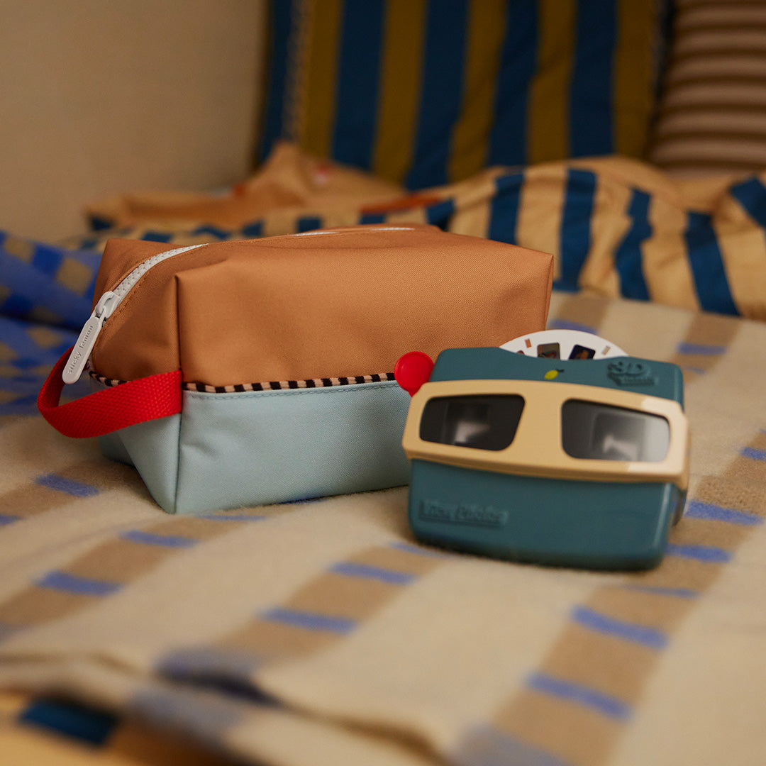 Sticky Lemon viewmaster naast een toilettas op een gestreepte deken.