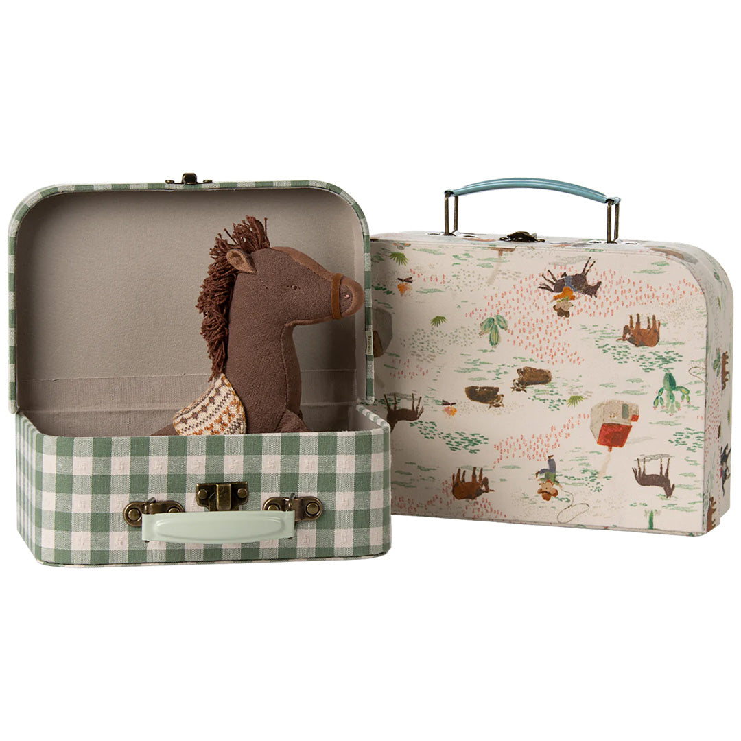 Een open Maileg decoratiekoffer met groen ruitpatroon en een bruine pluche pony erin, naast een gesloten koffer met pony- en westernpatroon.