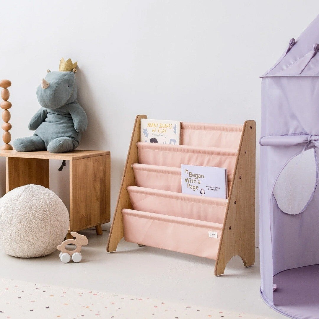 3 sprouts kinderboekenrek met boeken in een kinderkamer, naast een paarse speeltent.
