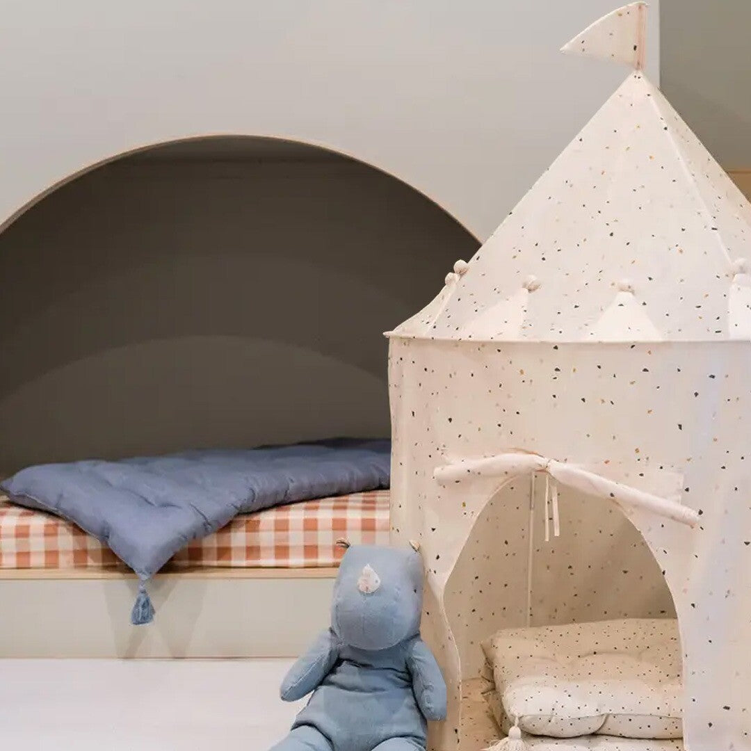 Beige kasteel speeltent met terrazzo patroon en een blauw knuffeldier ernaast.