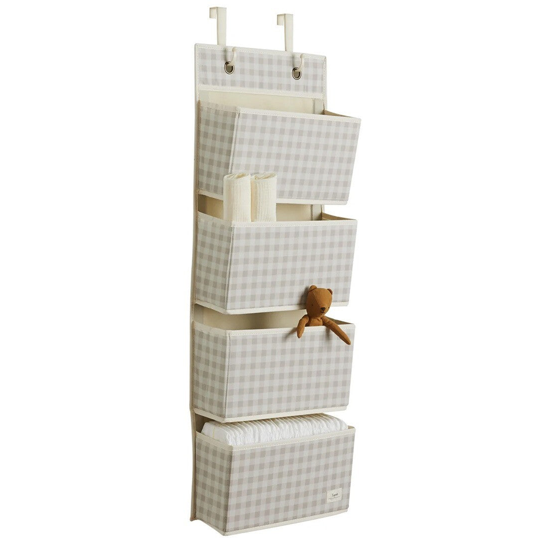 3 sprouts wandorganiser in beige geruit patroon met vier opbergvakken gevuld met babyspullen.