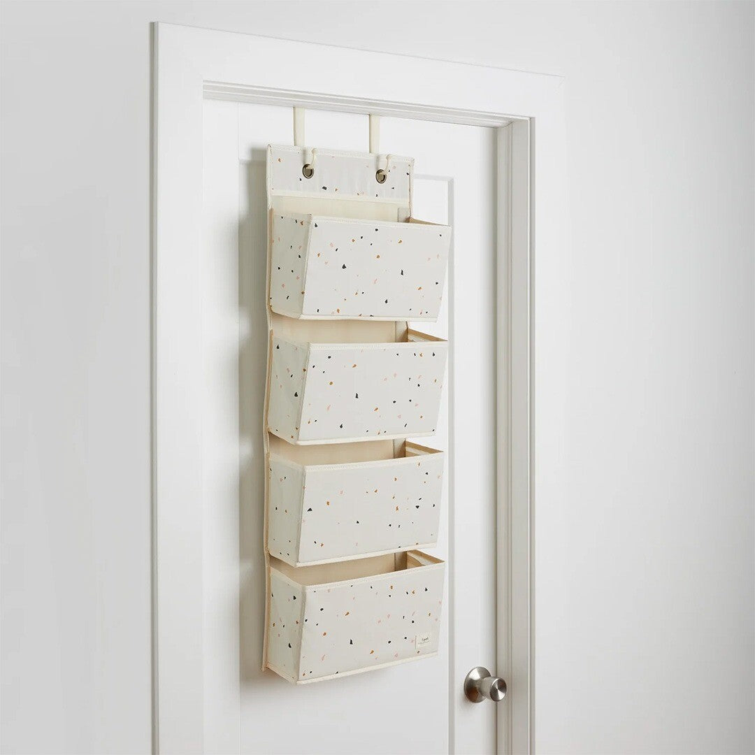 3 sprouts wandorganiser met terrazzo patroon hangend over een witte deur.