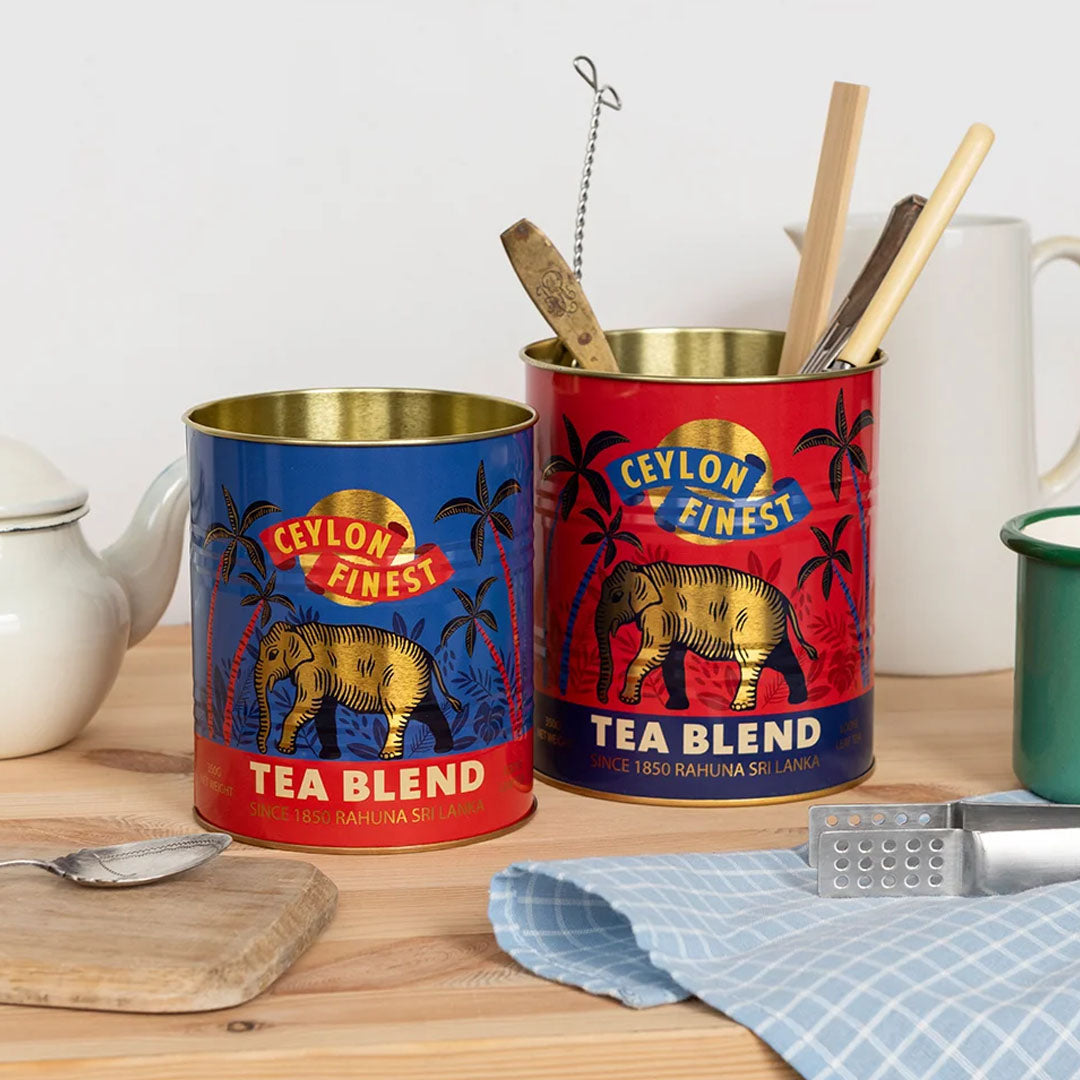 De twee Ceylon Finest opbergblikken op een houten aanrecht, gevuld met keukengerei.