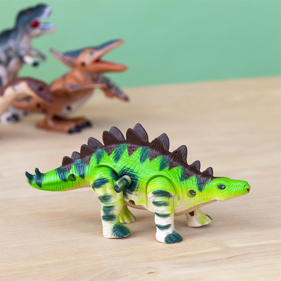 Rex London groen gestreept stegosaurus opwindspeeltje met opwindmechanisme op een houten ondergrond.