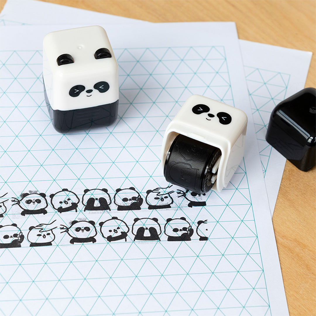 Twee panda stempelrollers op een tafel, waarvan één een rij panda gezichtjes op papier stempelt.