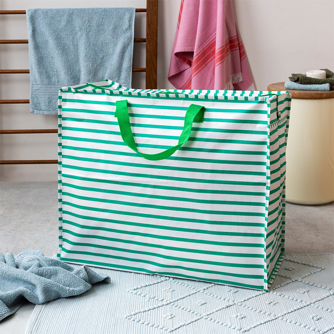 Rex London jumbo opbergtas met groene en witte strepen op een badkamermat.
