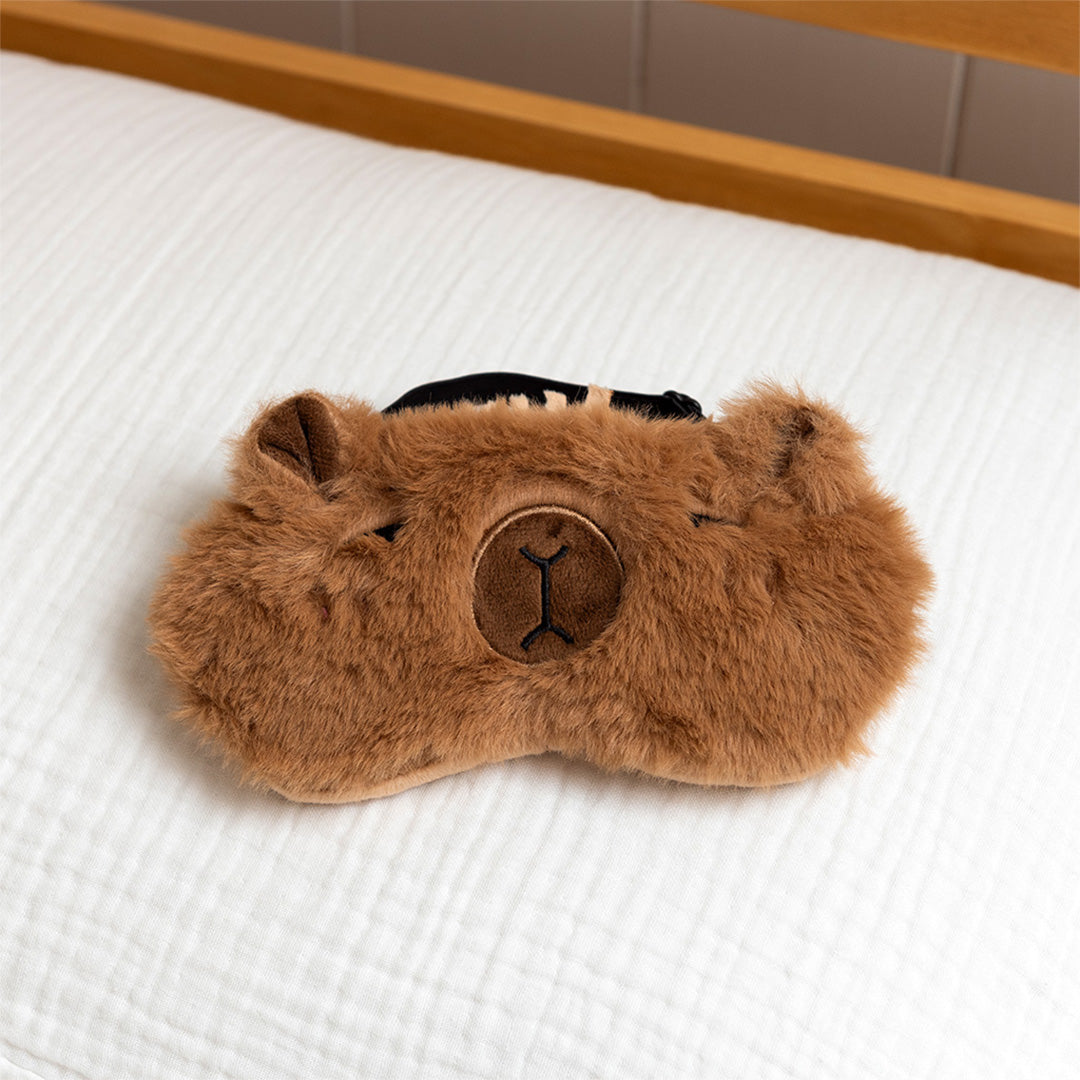 Rex London capybara slaapmasker op een wit bed.