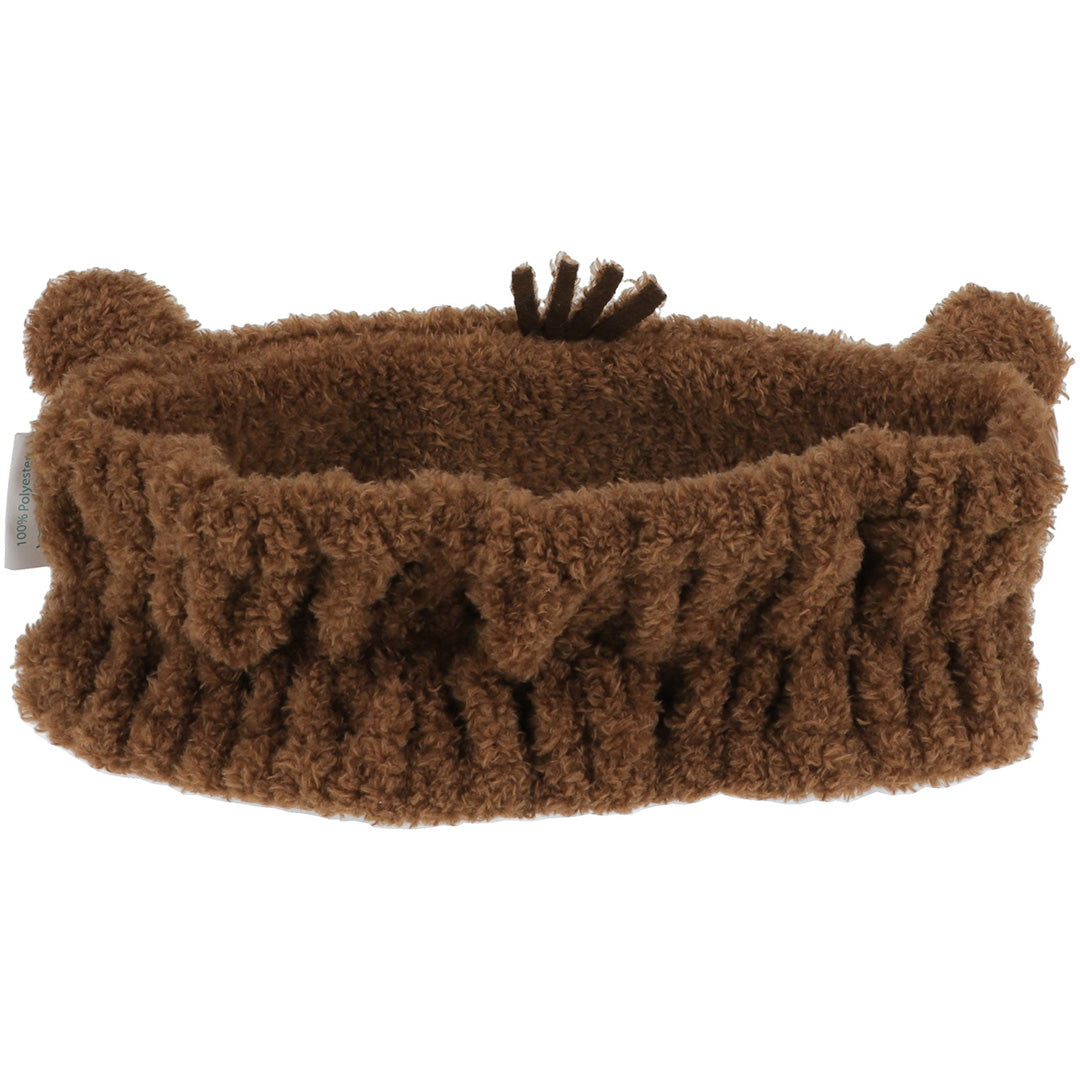 Achterkant van de bruine capybara haarband, met elastische plooien en een klein label.