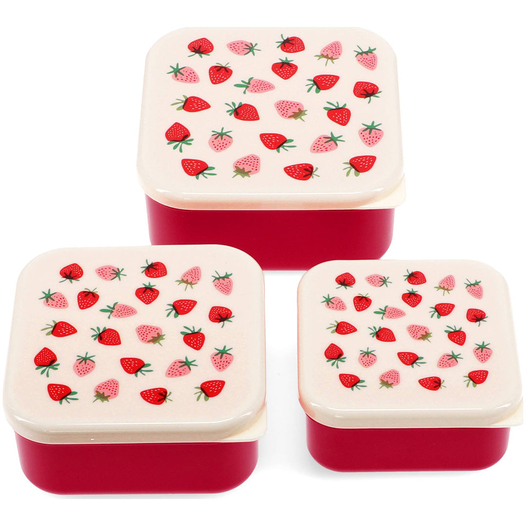 Drie Rex London vierkante snackdoosjes met rode onderkant en deksels met aardbeipatroon.