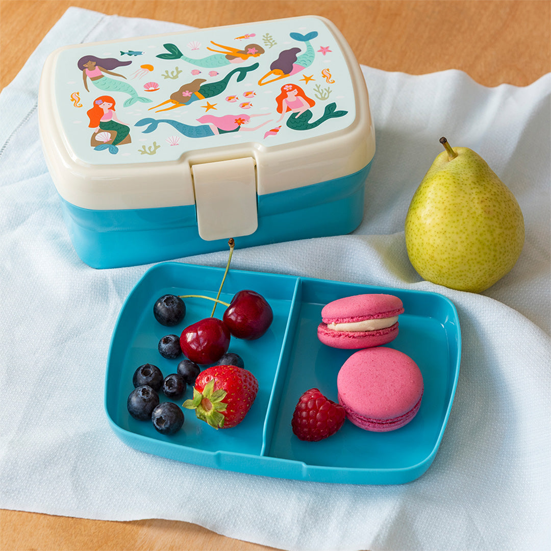 Rex London broodtrommel met zeemeerminnenpatroon en een los vakjesblad gevuld met fruit en macarons.