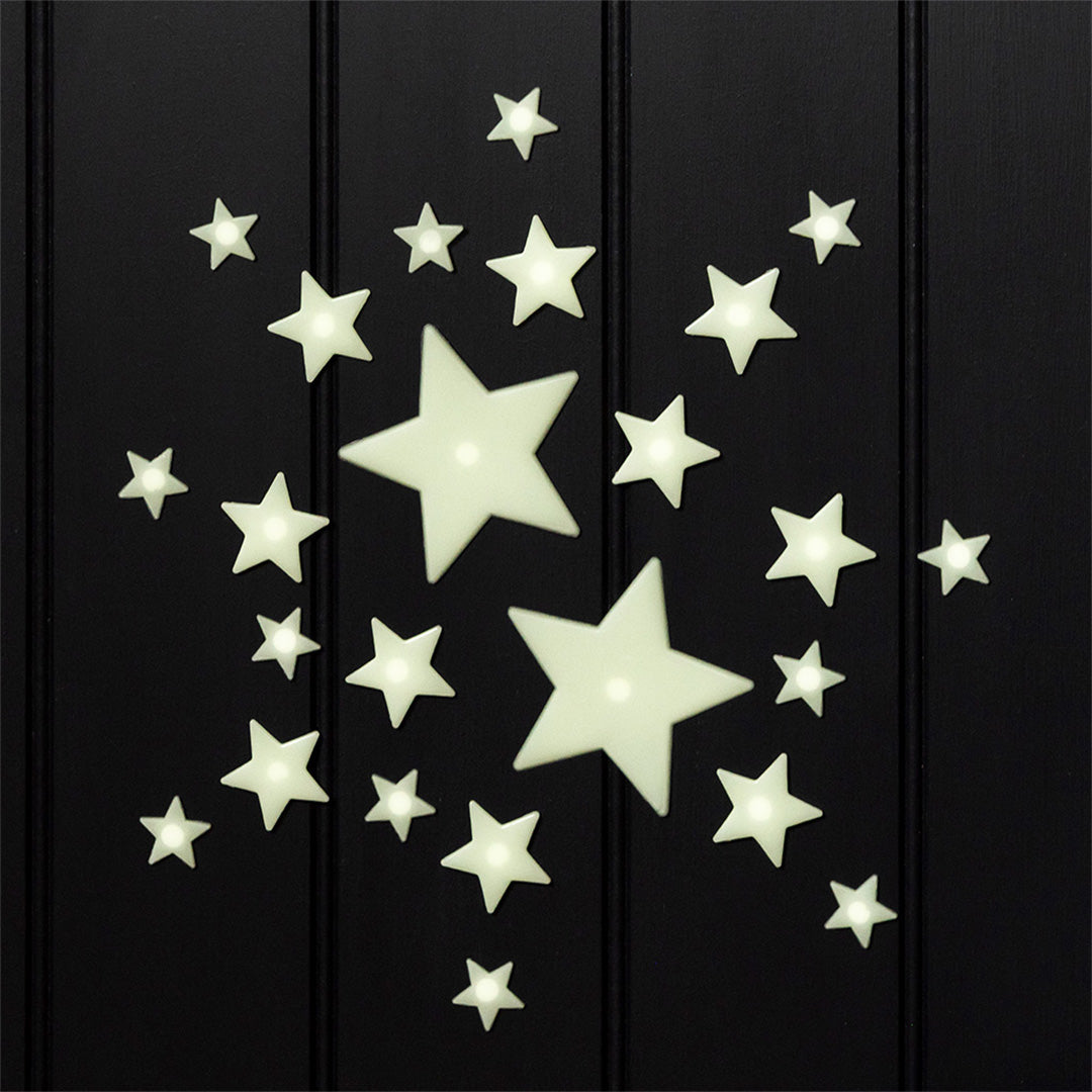 Glow-in-the-dark sterren decoratiestickers van verschillende formaten op een donkere ondergrond.