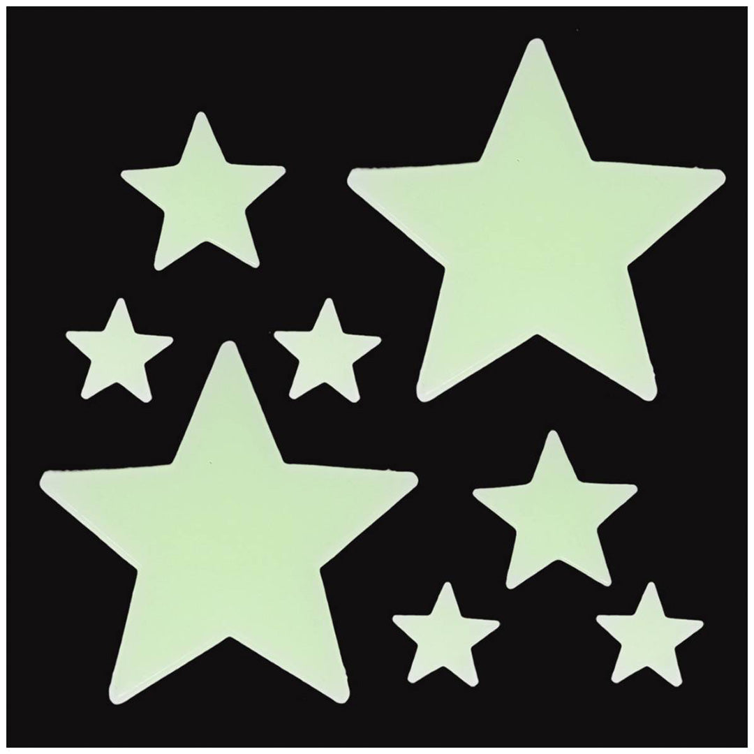 Close-up van glow-in-the-dark sterren decoratiestickers in diverse formaten op een zwarte achtergrond.