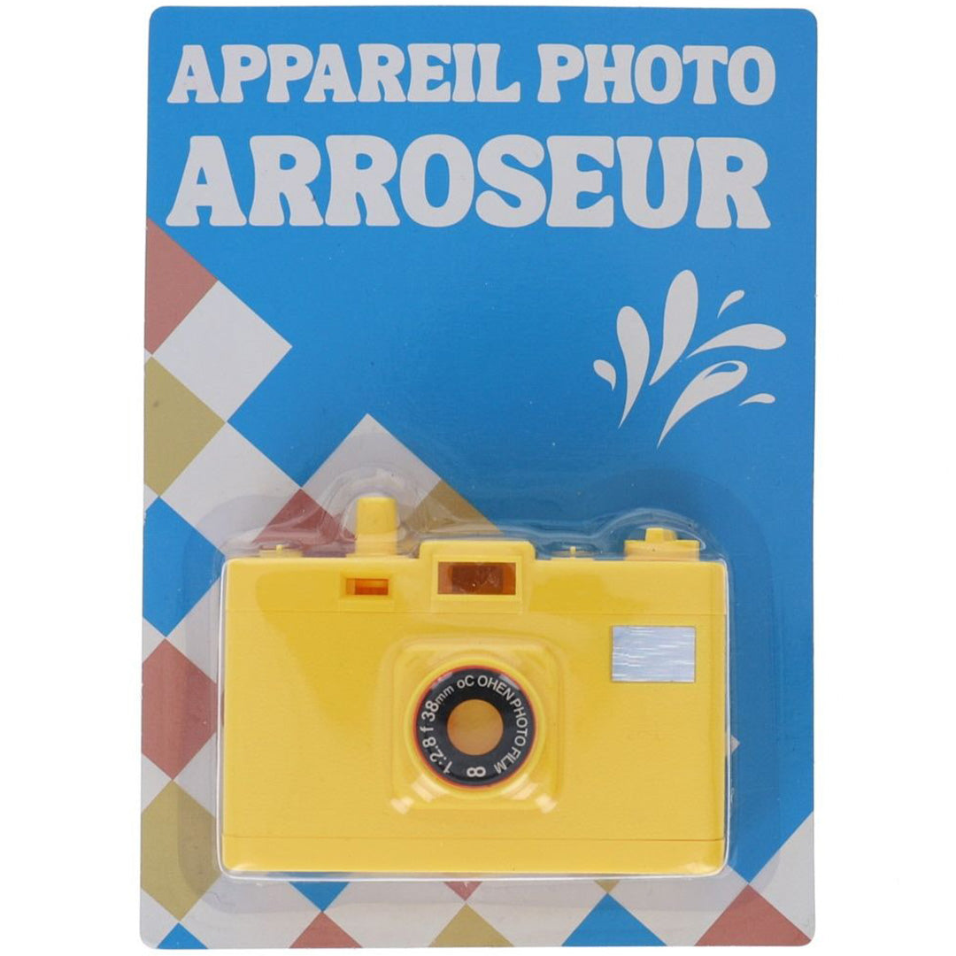 De voorkant van de verpakking van de gele le petit souk fopcamera, een plastic speelgoedcamera die water spuit.