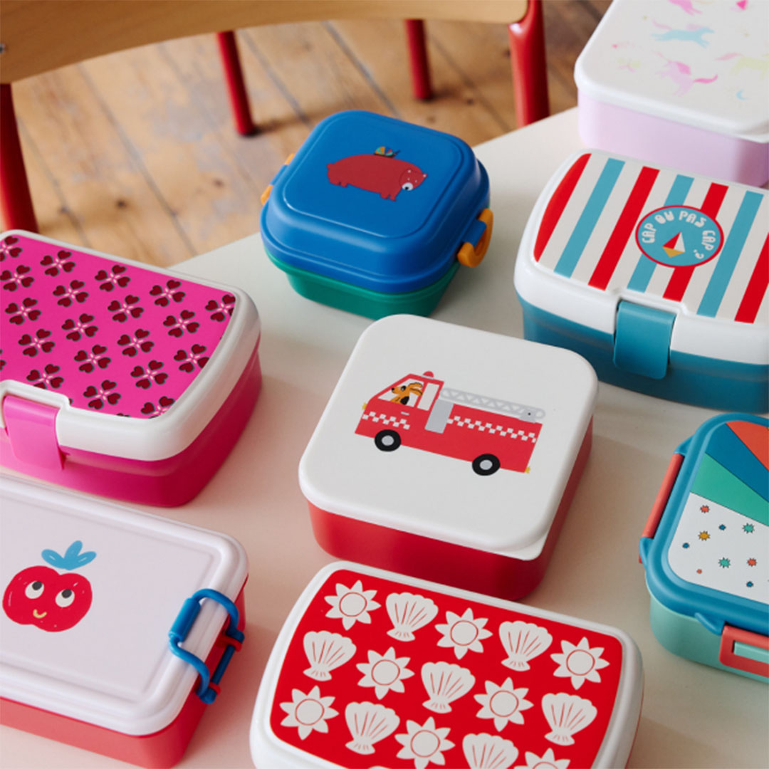 Collectie le petit souk broodtrommels met verschillende ontwerpen, waaronder voertuigen, dieren en patronen, op een tafel.
