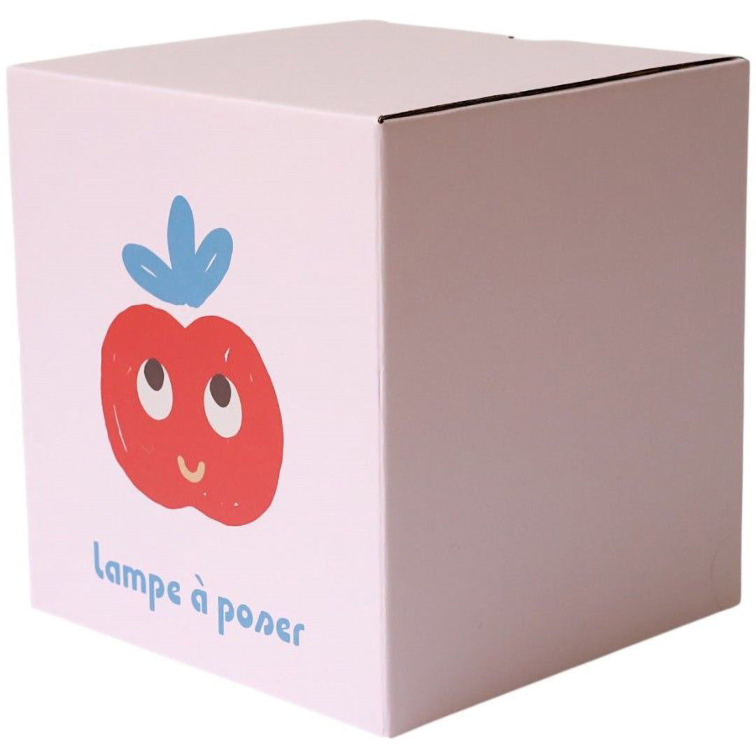 Verpakking van de Le Petit Souk kinderlamp, een lichtroze doos met een illustratie van de appel lamp.