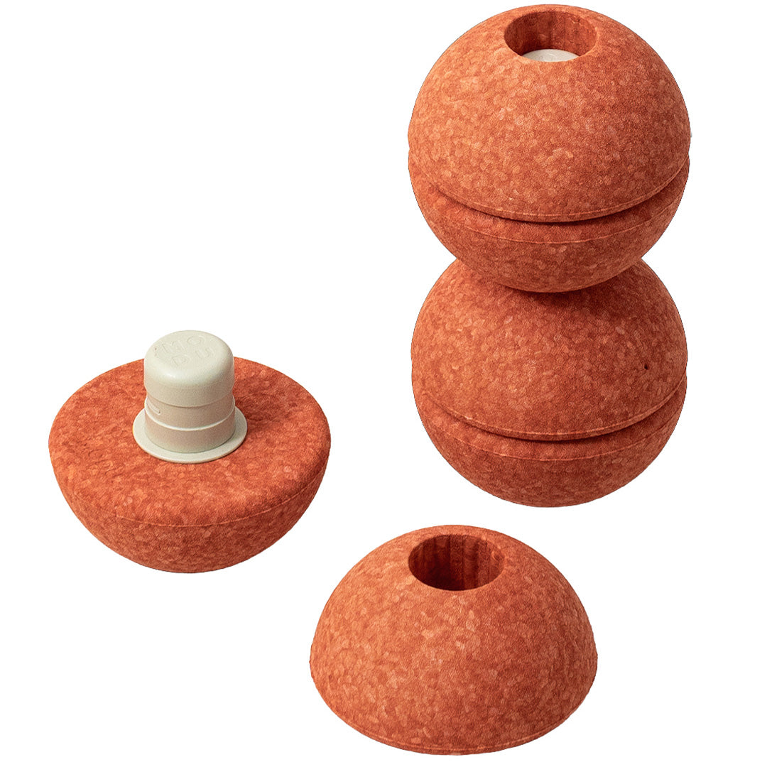 Drie Modu burnt orange schuimrubber halve ballen, waarvan twee gestapeld en één met een witte pin.