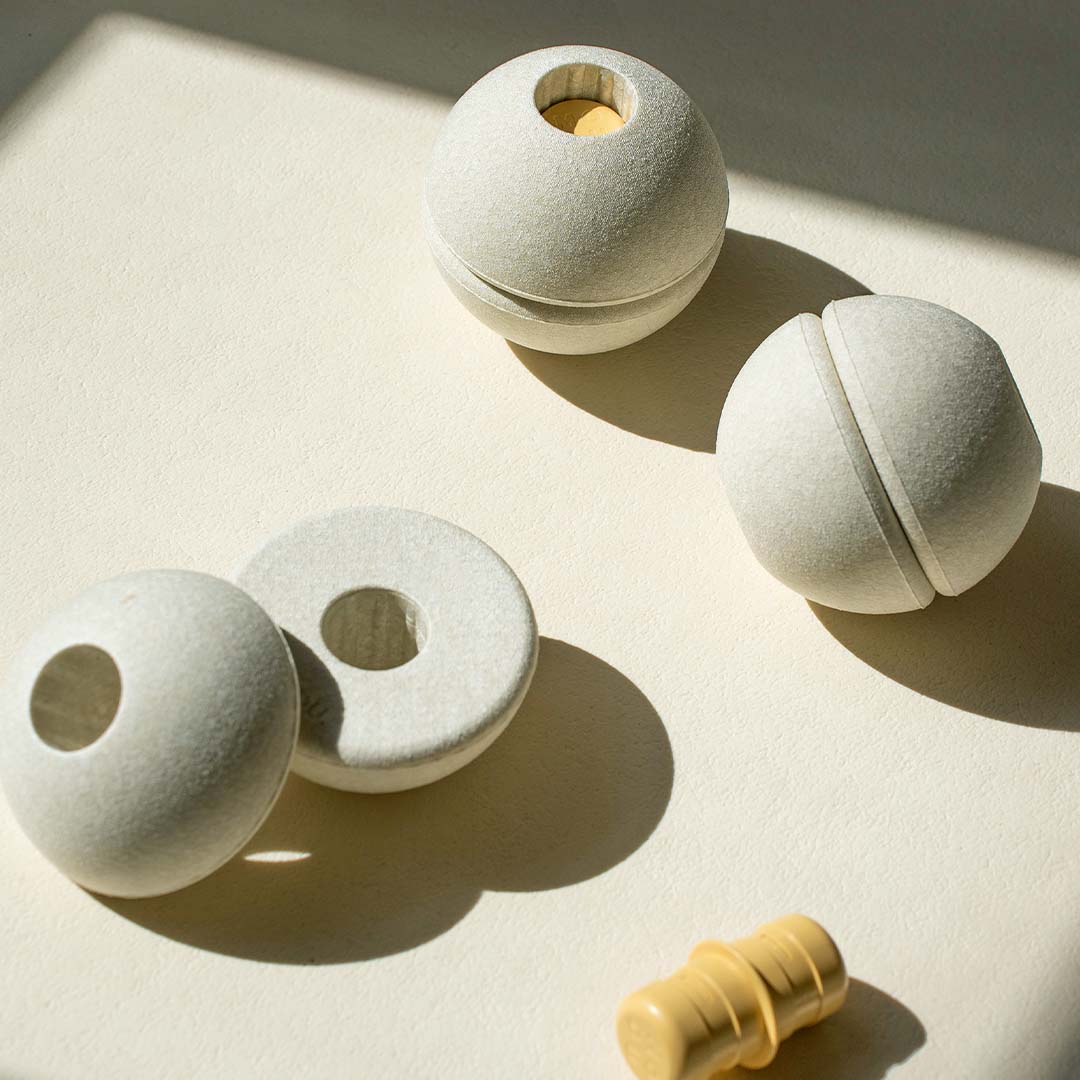 Detail van Modu beige schuimrubber bouwbal onderdelen en een gele pin op een lichte ondergrond.