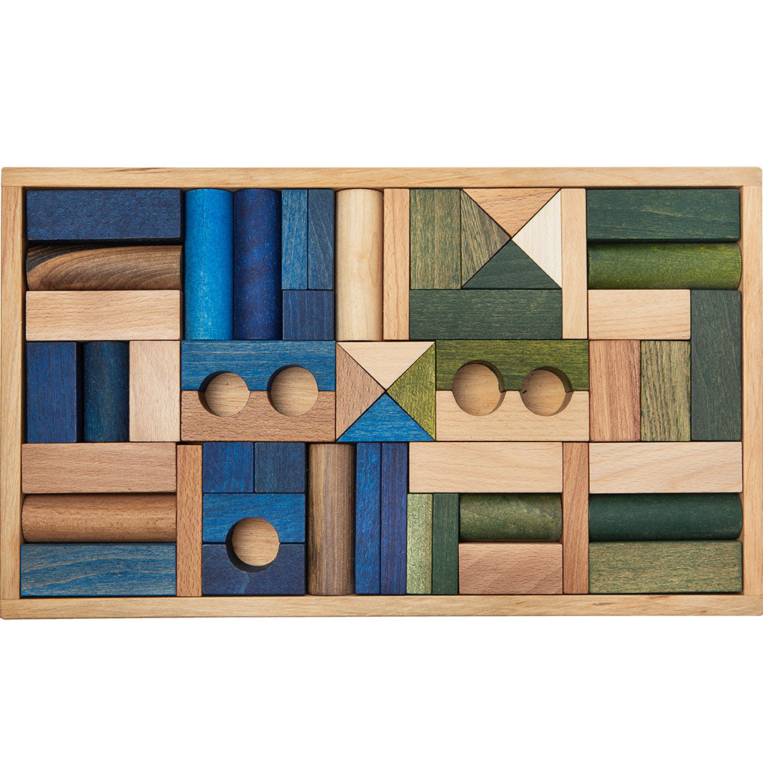 Wooden Story houten bouwblokken in een houten kist, met diverse vormen in natuurlijke, blauwe en groene tinten.