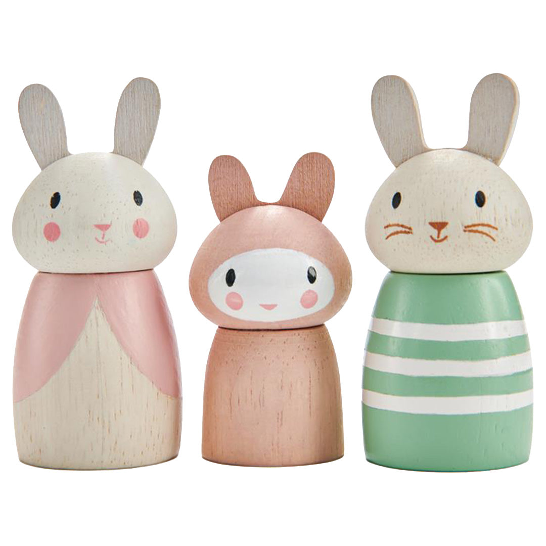 Drie Tender Leaf Toys houten konijnenfiguren, waarvan één roze met jurk, één kleine roze en één groen gestreept.