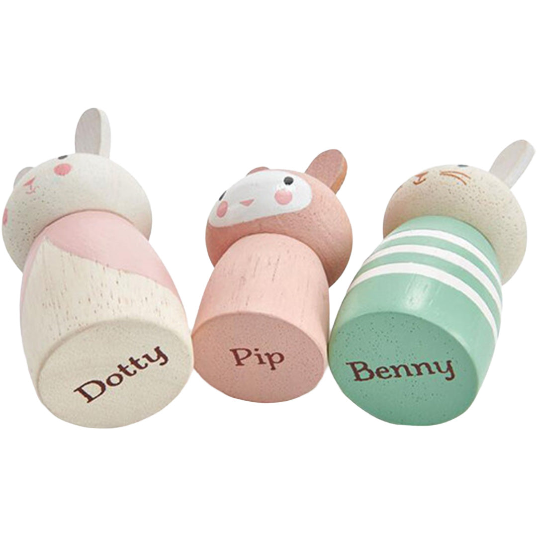 De onderkanten van drie Tender Leaf Toys houten konijnenfiguren liggen opzij, met de namen Dotty, Pip en Benny erop.