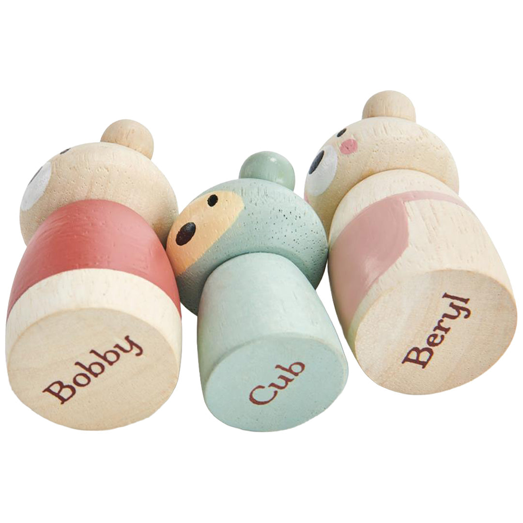 Drie houten beren poppenhuisfiguren liggen op hun zij, met namen 'Bobby', 'Cub' en 'Beryl' op de onderkant.