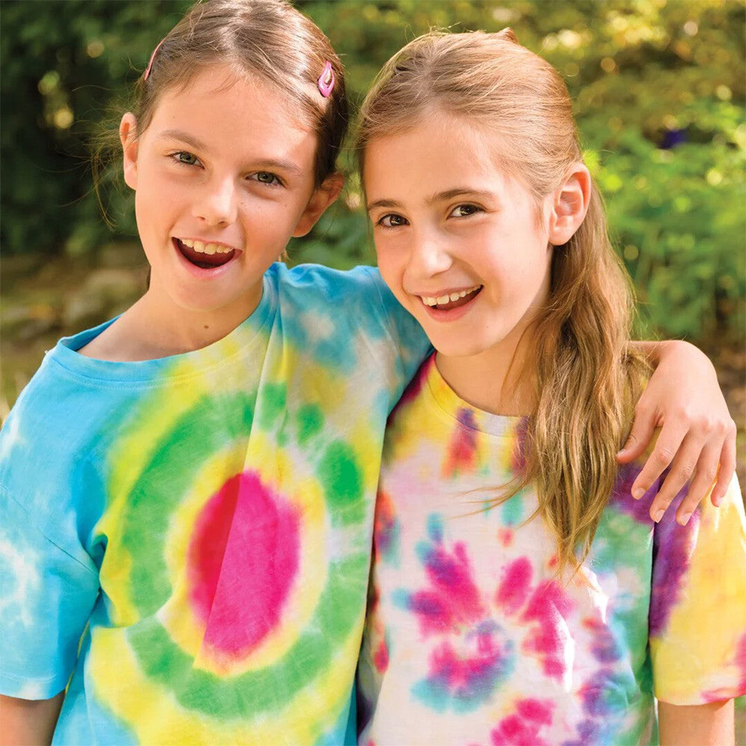 Twee lachende meisjes met kleurrijke tie-dye T-shirts, arm in arm.