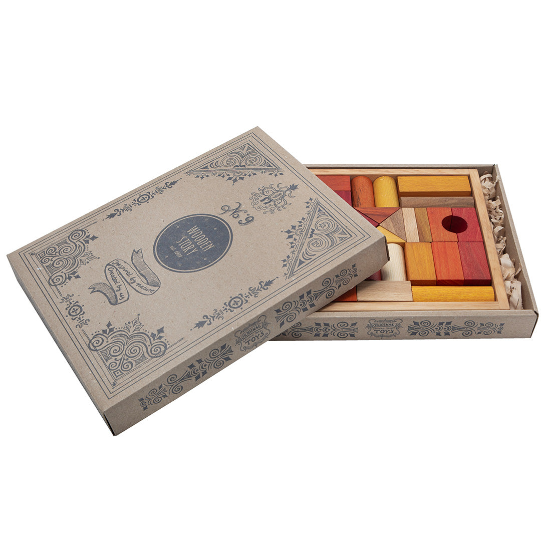 De verpakking van de Wooden Story houten bouwblokken, een open bruine kartonnen doos met decoratieve opdruk.