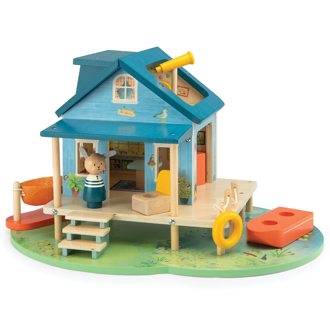 Moulin Roty houten poppenhuis 'huis aan het meer' met een konijnenfiguur en een telescoop.