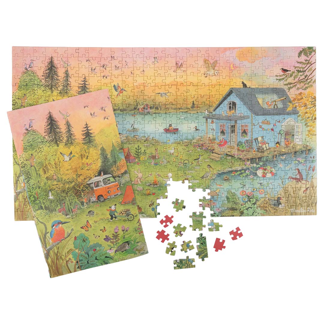 De complete Moulin Roty legpuzzel met een voorbeeldposter en enkele losse puzzelstukjes ernaast.