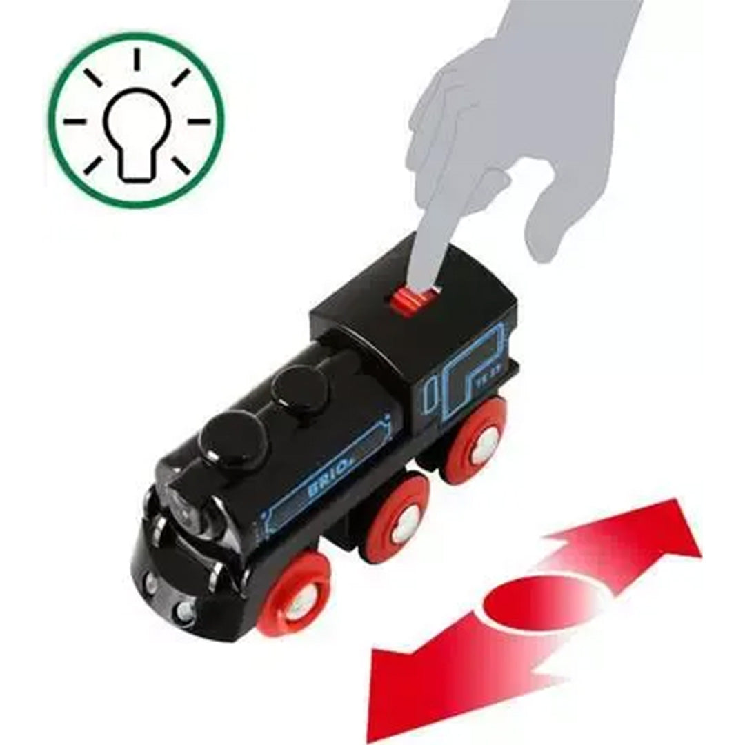 Brio oplaadbare speelgoedlocomotief met een hand die de rode schakelaar bedient, met iconen voor licht en rijrichting.