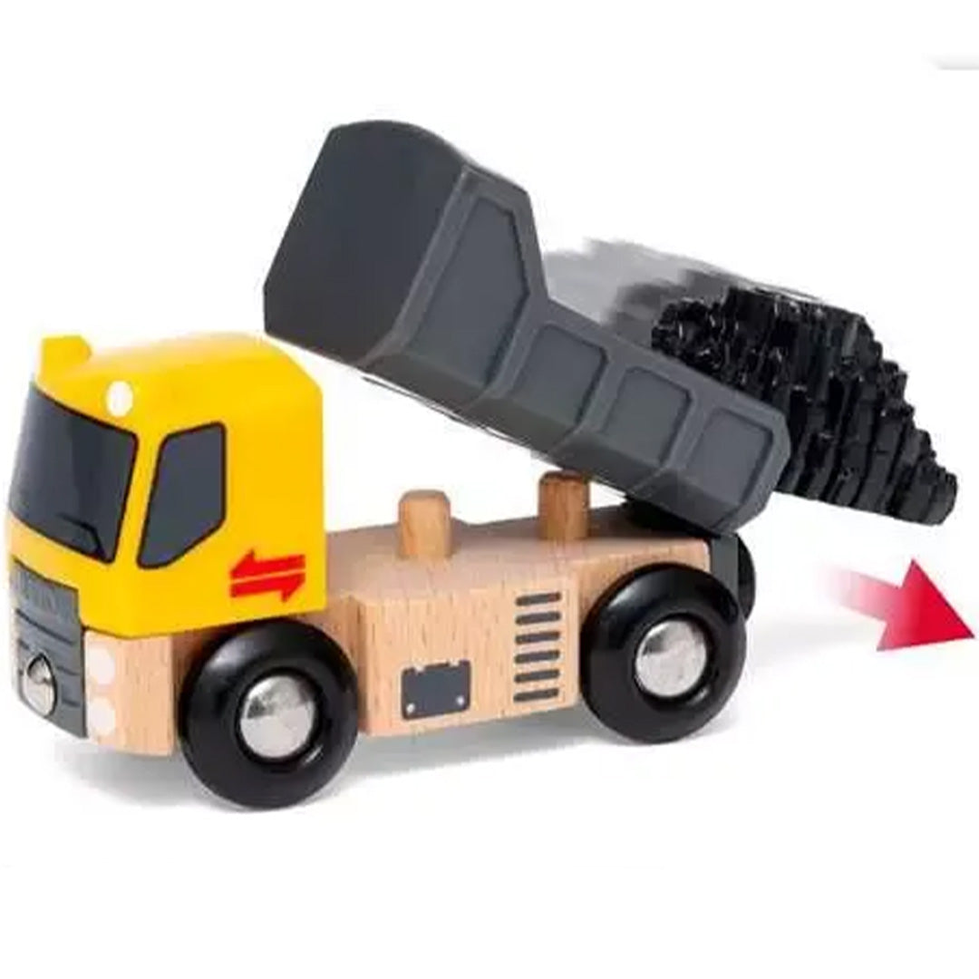Een Brio houten kiepwagen met de laadbak gekanteld, waaruit zwarte lading valt, met een rode pijl die de kiepbeweging aangeeft.