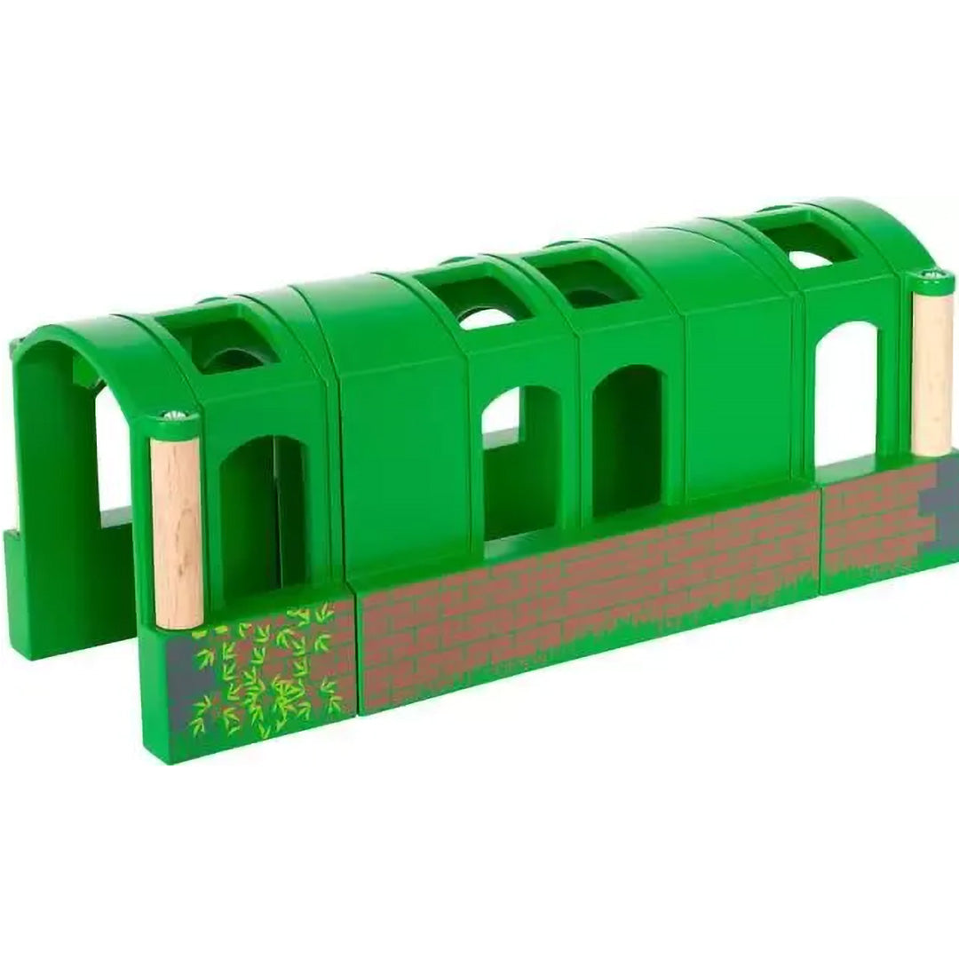 Brio flexibele tunnel voor speelgoedtreinen, volledig uitgeschoven, groen met baksteen- en bladerpatronen.