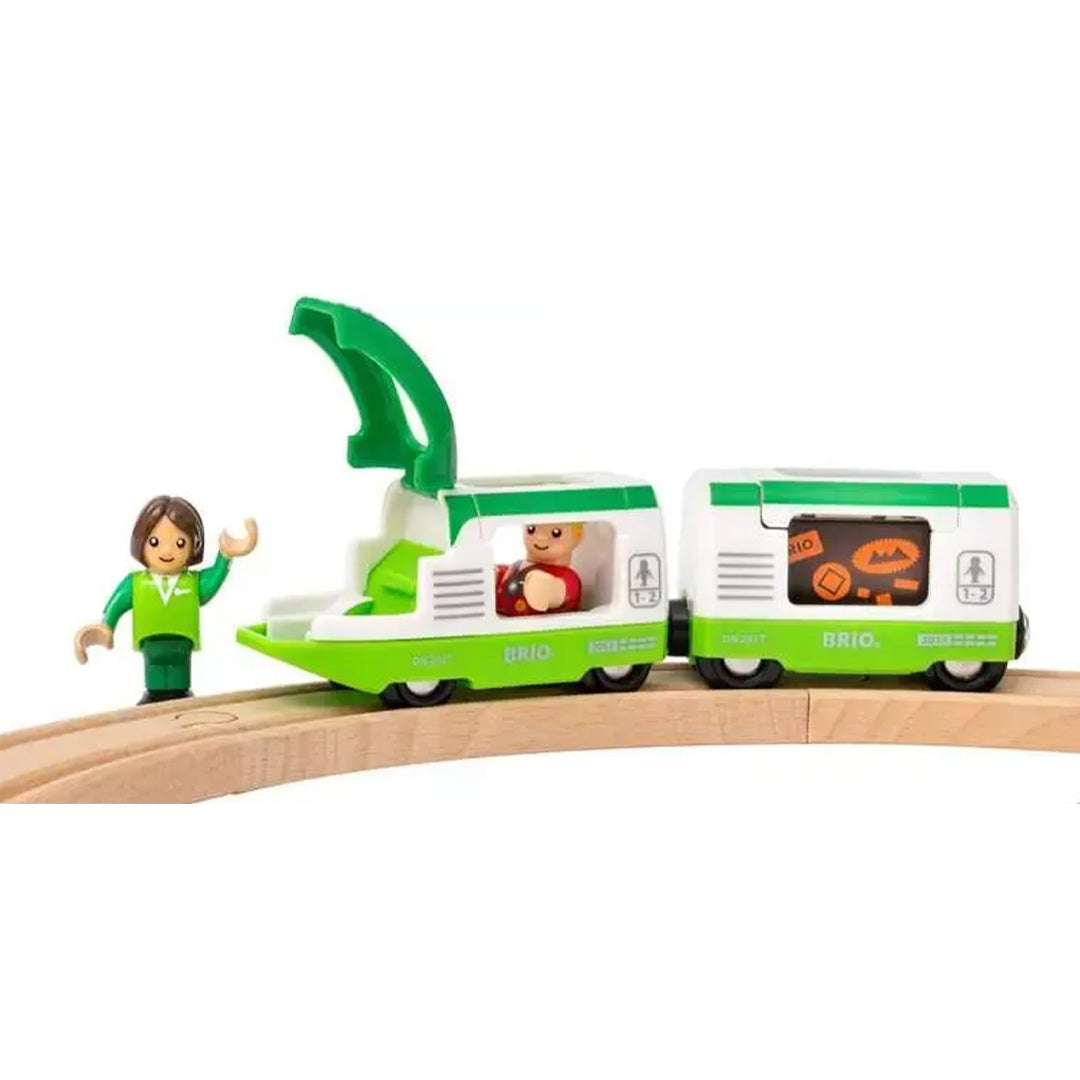 Close-up van de Brio groene trein op de houten rails met een open dak en twee figuren.