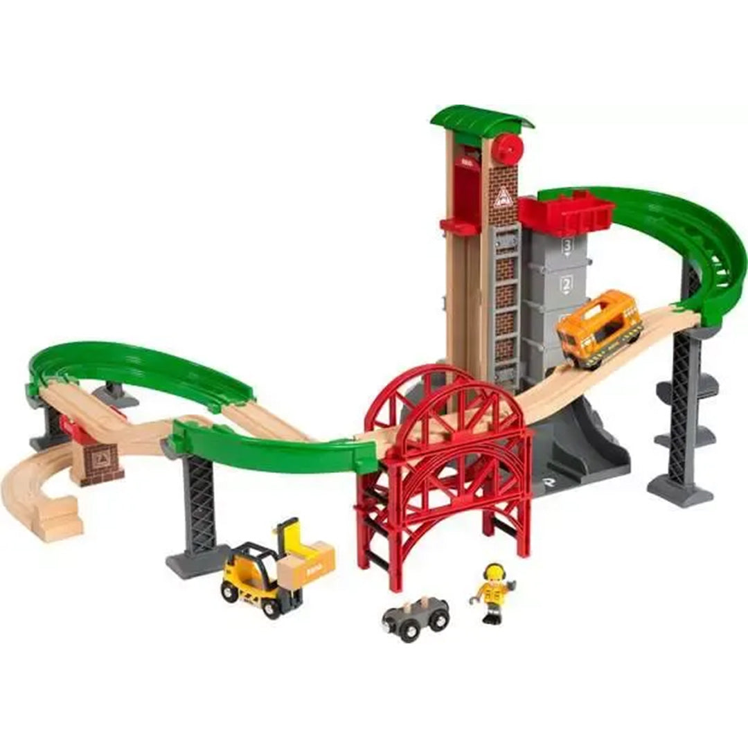 Brio houten treinbaan set met een oranje trein op de rails, een toren met lift, een rode brug en diverse voertuigen.