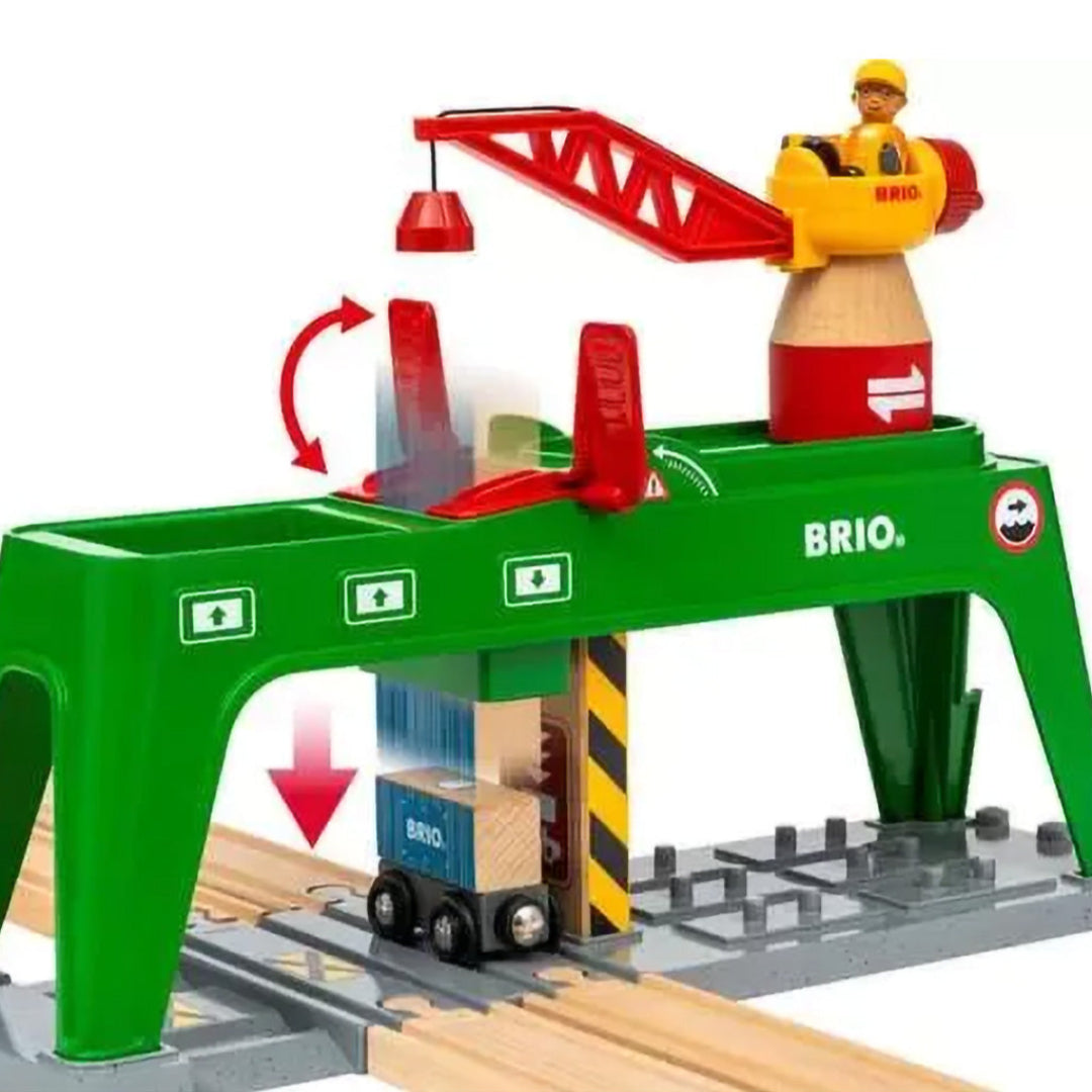 Brio container kraan speelgoed die een blauwe container op een treintje laadt, met bewegingspijlen.