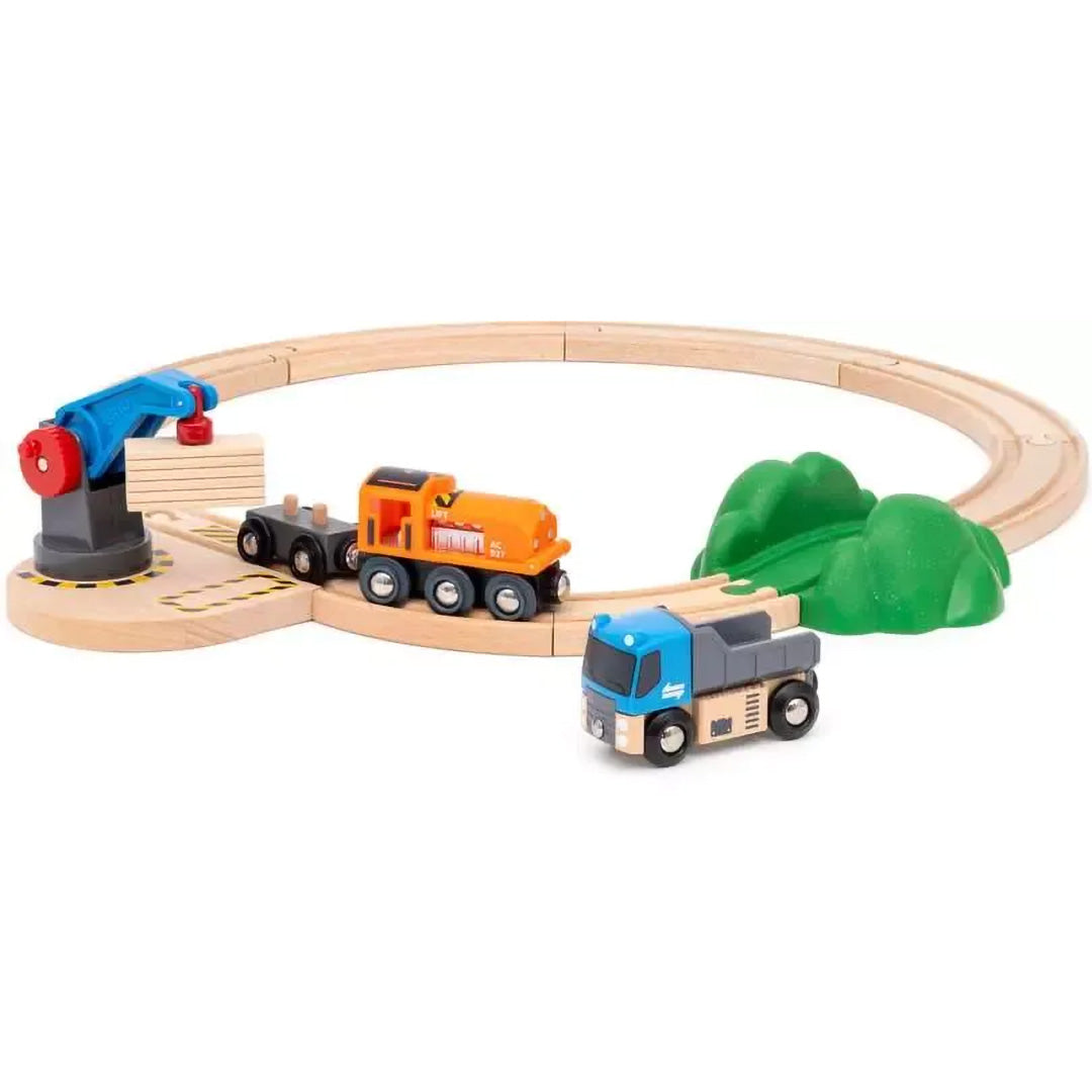 Brio houten treinbaan met oranje trein, blauwe kiepwagen, kraan en groene heuvels.